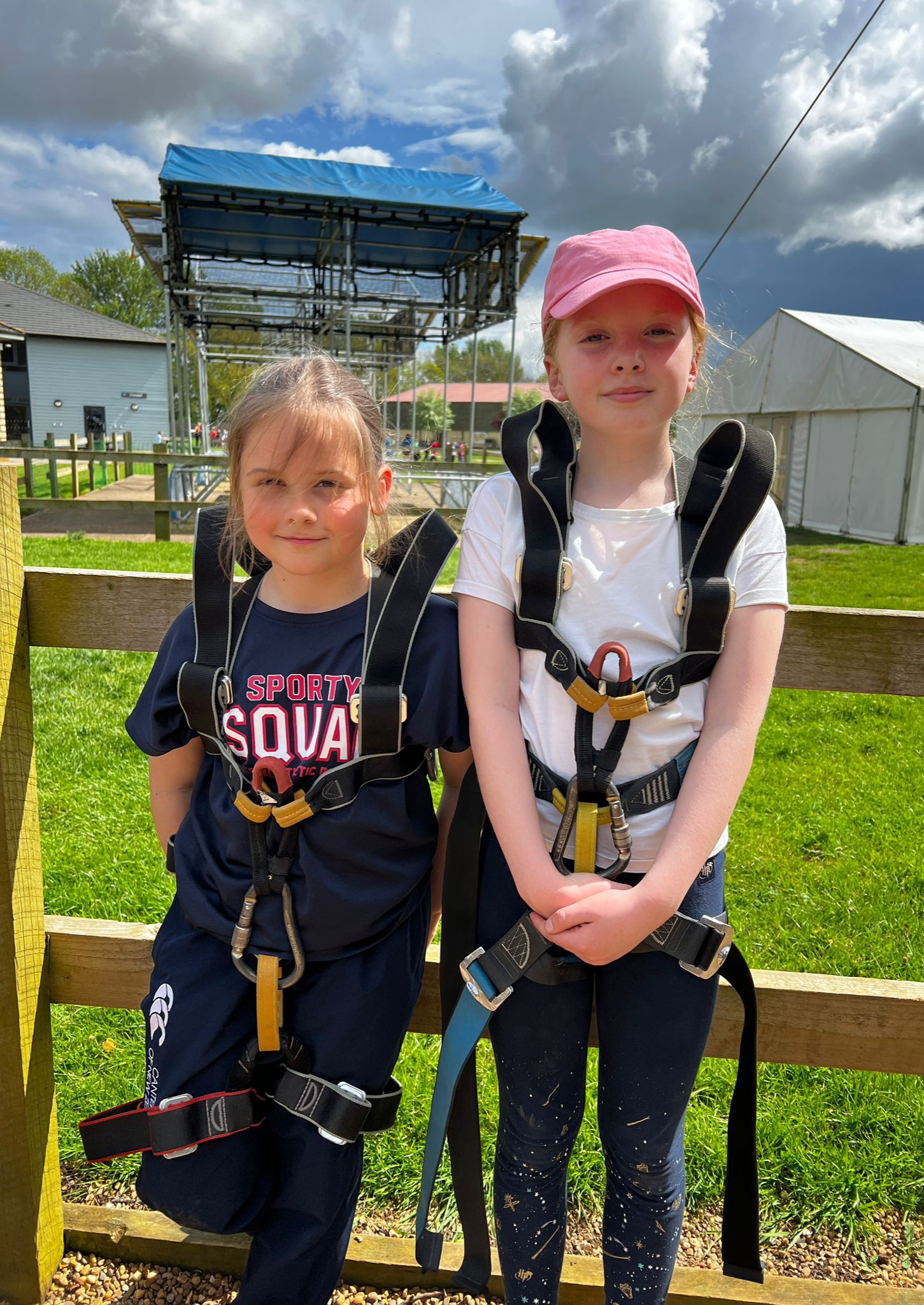 Two girls wear their harnesses as they prepare for an activity at PGL